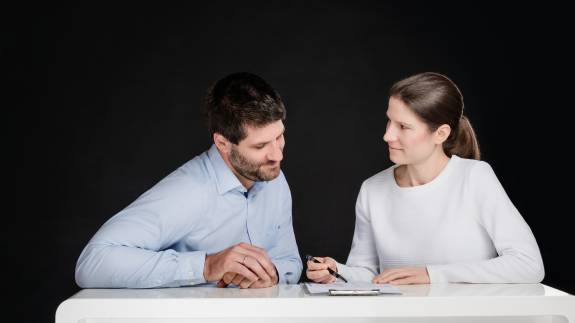 Priv.-Doz. Dr. med. Katharina Lechner und Dr. med. Benjamin Lechner sitzen an einem Tisch und besprechen gemeinsam Unterlagen.