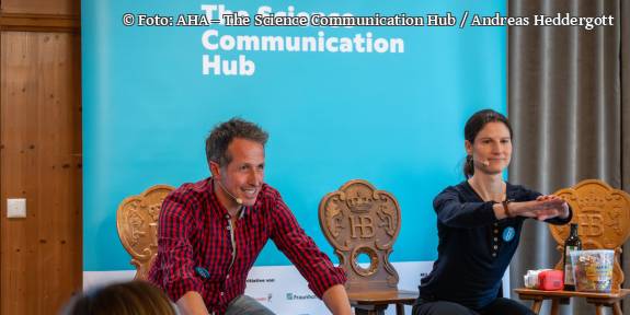 Mann und Priv.-Doz. Dr. med. habil. Katharina Lechner mit Headsets bei einer interaktiven Präsentation auf der Bühne des „Science Communication Hub“